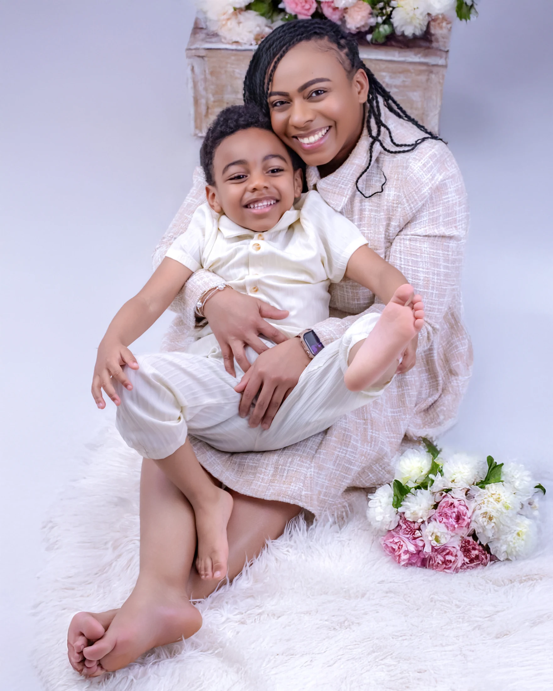 Mother holding her laughing child in a light studio setting