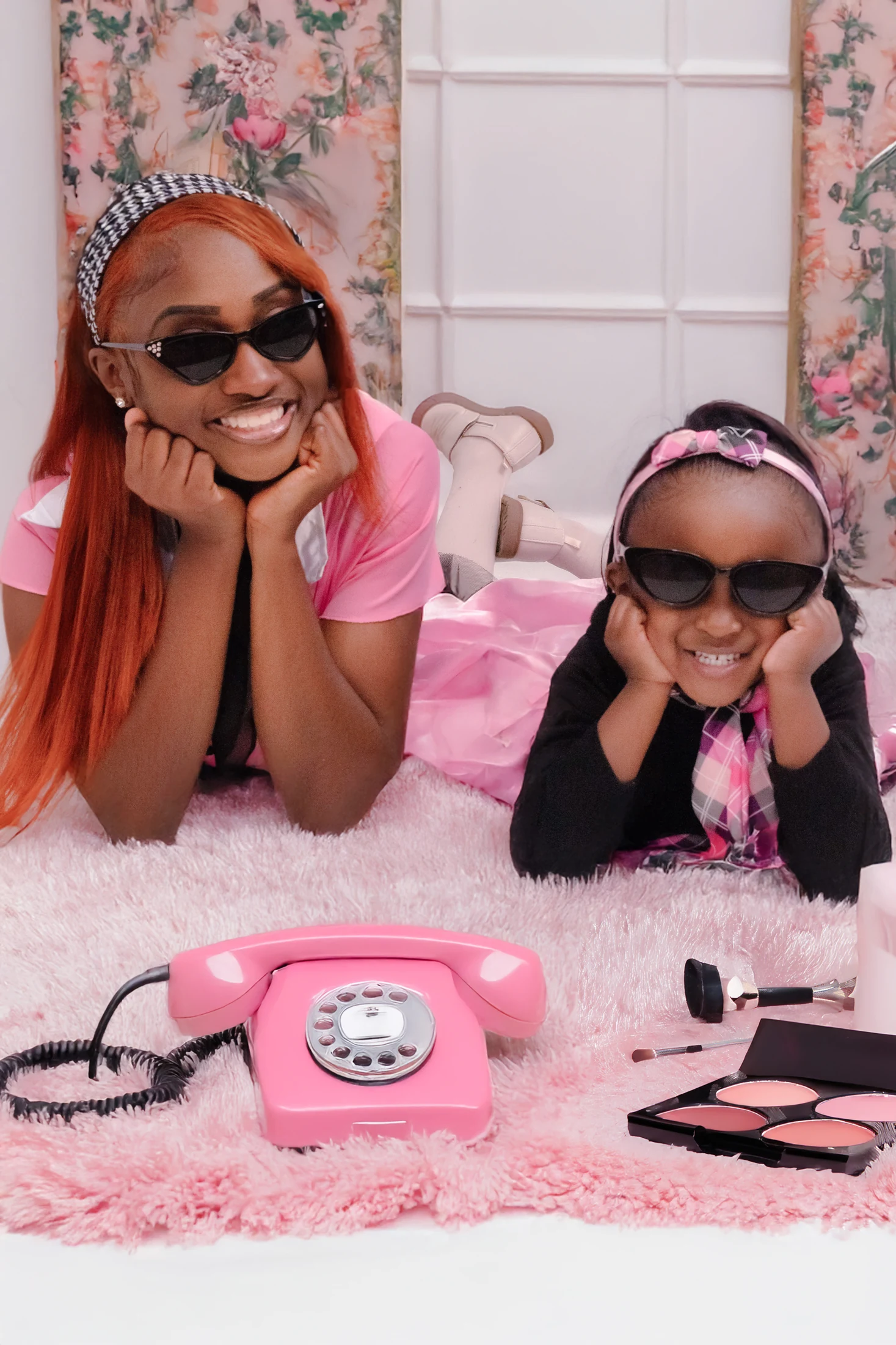 Mother and daughter smiling in a playful pink portrait set