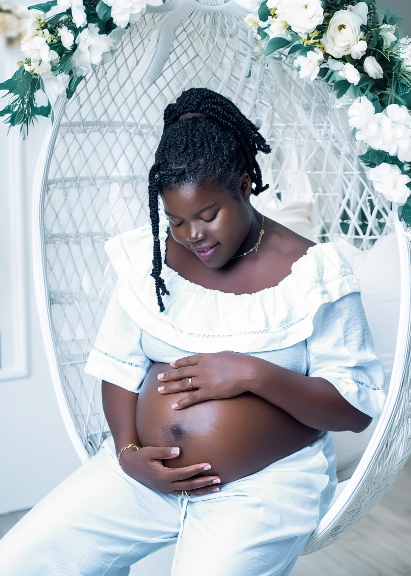 Expectant mother in white cradling her belly